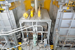 溶体化処理炉で加熱した搬送トレーを焼き入れ水槽に投入することで、水温を上昇させる（左）。　様々なアイディアを盛り込み、極限まで炉の温度低下を抑えた溶体化処理炉に部品を投入（右）<br><span class="fontSizeS">（写真提供：ホンダ）</span>