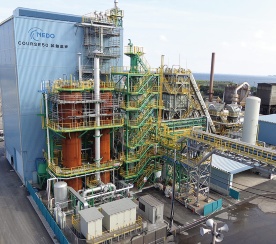 2015年9月に完成した試験高炉は写真左奥の青い建物内にある。内容積は12m<sup>3</sup>で、従来の高炉の約400～500分の1の規模になる<br><span class="fontSizeS">（写真：NEDO・日本鉄鋼連盟：COURSE50）</span>
