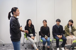 ユーグレナの役員を前にプレゼンする小澤さん(右写真の右端)。小澤さんと共に「目指したい社会」を考えたFutureサミットメンバーと事務局のスタッフたち(左)<br><span class="fontSizeS">(写真:ユーグレナ)</span>