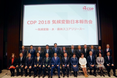 The CDP announcement in Tokyo on January 22, with leaders including Asahi Group Holdings president Koji Akiyoshi, Sumitomo Forestry president Akira Ichikawa, and Marui Group president Hiroshi Aoi on the stage.