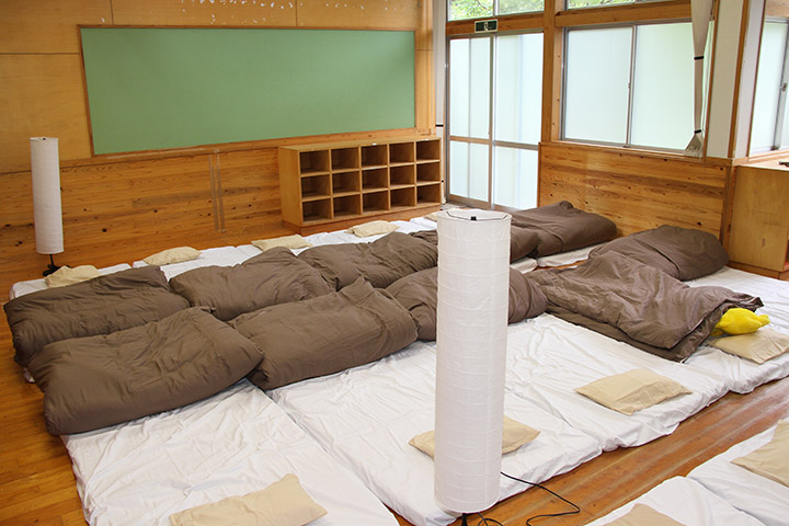 小学校の外観と改修後の寝室（写真：八代市）