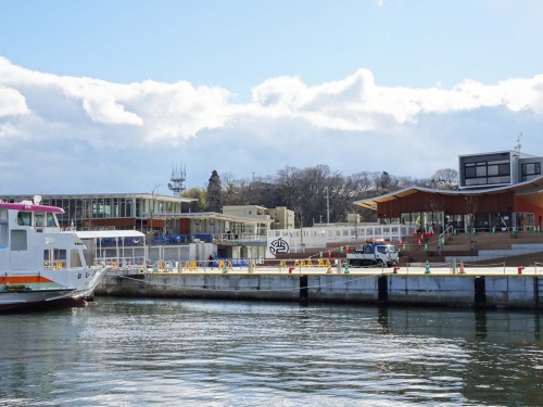 左に写るまち・ひと・しごと交流ブラザは、市が総事業費14億円をかけて建設。観光物産交流センターと勤労青少年ホームの機能のほか、交流センターの機能も。右手のムカエルは県と市の補助金約3億3000万円を活用して建設。飲食店・物販店など6店舗が入居する(写真:日経BP総研)