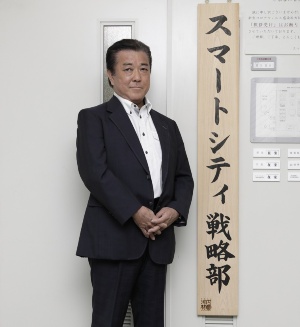 坪田 知巳氏。スマートシティ戦略部の入り口にある看板の前で(写真:行友 重治)