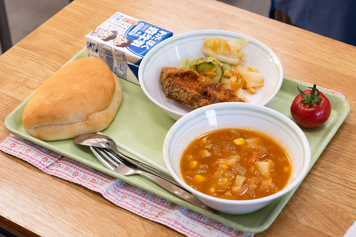 6年生の給食に初めてトマトが丸ごと１個提供された。「めっちゃうまい。甘みがあって、おいしいです」と嫌いなトマトにかじりつく子供も（写真：2点とも長坂 邦宏）