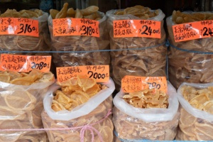 香港の乾物屋街では、高価な乾物が当たり前に販売されている。左は最近人気の高い魚の浮き袋で、この店では1斤（約600g）で1万円～4万5000円程度。右の鮑専門店では、貴重な超巨大干し鮑には1斤130万円以上の価格がついていた