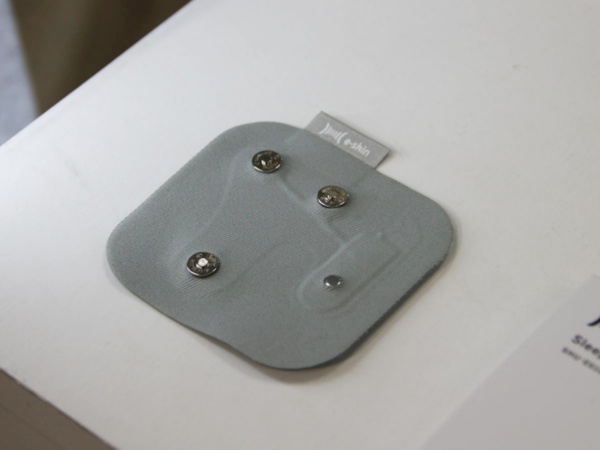 ワッペン型の基板。左側の3つのスナップボタンはハブを接続するためのもの。右側の銀色の部品が温度センサー（撮影：Beyond Health）