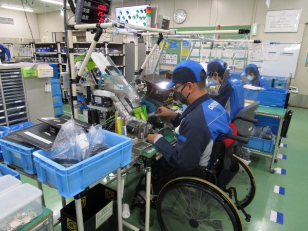 袋を一枚取って開けるという作業を自動化することで、麻痺がある人も付属品の袋詰め作業が担当可能となる（写真：オムロン京都太陽）