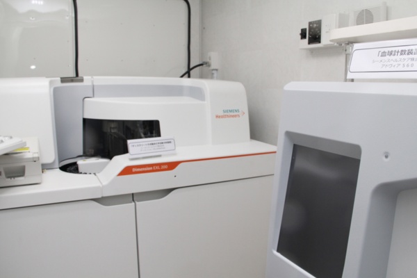 検査用車両荷台の前部に搭載した免疫・生化学分析装置。右手前にはあるのが自動血球計数装置