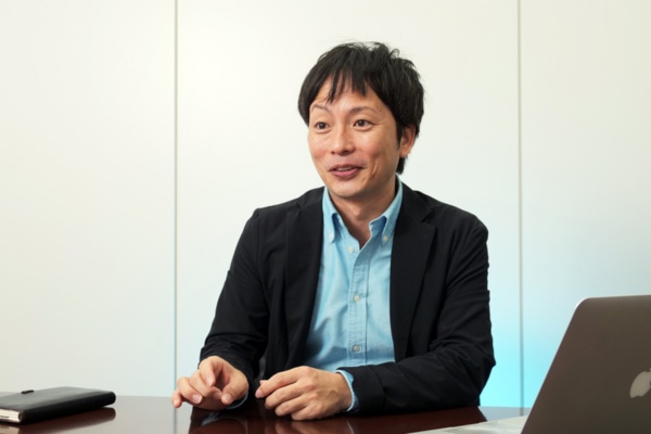 トータルウエルネスプロジェクトオキナワ統括プロデューサーの菊池 和登氏。IT企業時代に、不規則な食生活や体のケア不足で体調を崩す。それが一つのきっかけとなり、IT分野からウエルネス分野に転身した(写真:新関 雅士)