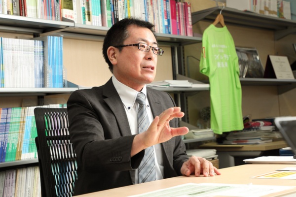 東京大学高齢社会総合研究機構機構長・未来ビジョン研究センター教授の飯島勝矢氏。後ろに見える黄緑色のTシャツが、フレイルサポーターの着るユニフォームだ（写真：花井 智子、以下同）