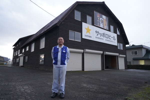 一世紀近く使われているサッポロビール北海道原料研究センターの建物と、センター長の鯉江弘一朗さん（写真：塩見なゆ）