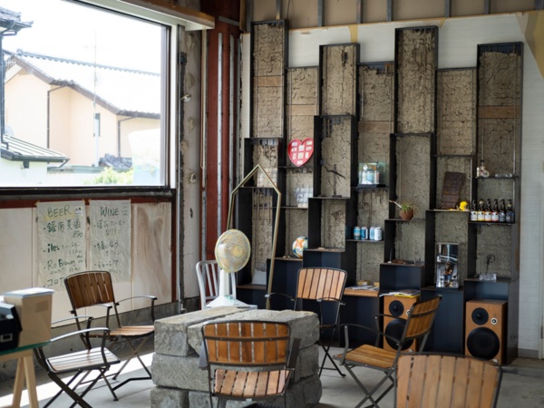 パクチー銀行内のカフェスペース。後方の壁を埋めるのは鋸南町内の古民家の土壁を利用した「SOTOCHIKU」(写真:栗栖誠紀)
