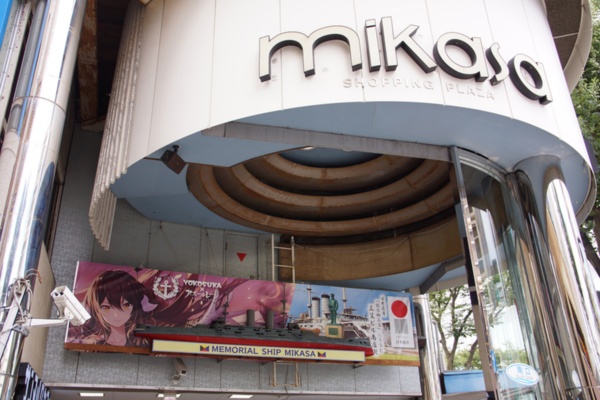 市内「三笠ビル商店街」の入り口にかけられているコラボ企画の横断幕。横断幕の左側に描かれているのが、ゲーム「アズールレーン」の女性キャラクター「三笠」。記念艦「三笠」は横須賀市の歴史資産であり、また三笠ビル商店街の名は記念館「三笠」にちなむ(写真撮影:筆者)