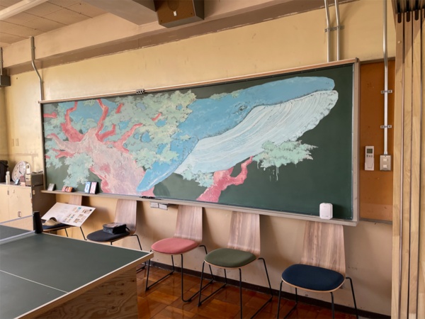 宿泊室の黒板を使ったクジラのチョーク絵。近隣の東京藝大の学生の力作だ（写真：日経BP 総合研究所）