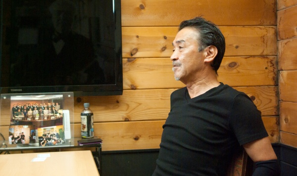 プラネット代表取締役会長の小池和人氏。堀貞一郎氏と共に写った写真を前に、思い出を語ってくれた（写真：バウム）