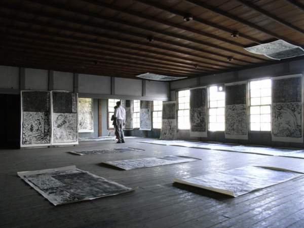 写真は2007年の「『まち』がミュージアム！」で旧・下吉田町役場に展示された、堀尾貞治さん（絵）と周治央城さん（彫）共作による木版画（写真提供：「まち」がミュージアム！ 実行委員会）