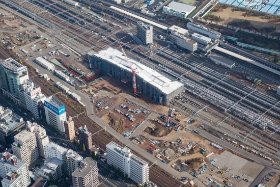 (写真1)建設工事が進む高輪ゲートウェイ(高輪GW)駅を南西方向の上空から見る。駅舎の左手、西口の一帯では土地区画整理事業による基盤整備が進む(画像提供:JR東日本)