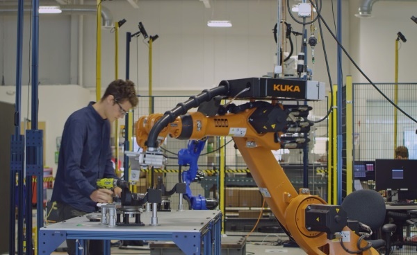 (写真1)作業台を挟んでロボットと人間が協働で作業を行う