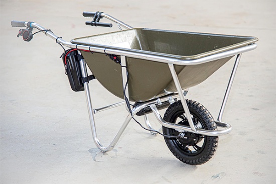 工事現場でよく使われる土砂運搬用のバケットを備えた一輪車にE-Cat Kitを取り付けた例。電池をバケット下に、コントローラーバッグをハンドル下の支柱に取り付けている（写真提供：CuboRex）