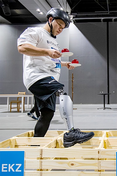 障害物を越えるパワード義足の滑らかな動きに注目が集まった。手に持つりんごはイミテーションでとても軽いため、より難しいタスクになっている(写真提供:BionicM ©Takao Ochi/Kanpara Press)