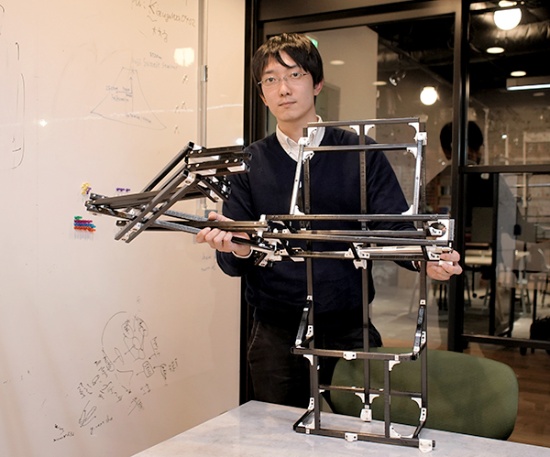 田中一敏氏(写真は開発中のカーボンファイバー製卓球ロボット:田中氏提供)。2017年東京大学大学院情報理工学系研究科博士課程修了。同研究科特任研究員を経て、2019年4月からオムロンサイニックエックス株式会社シニアリサーチャー。現在は、工業用組み立てロボットのAI化などを担当しつつ、業務時間の20%を自由に使える「20%ルール」を使い、スポーツするヒト型ロボットのための設計法、制御法、行動計画について研究している。2018年日本ロボット学会研究奨励賞受賞