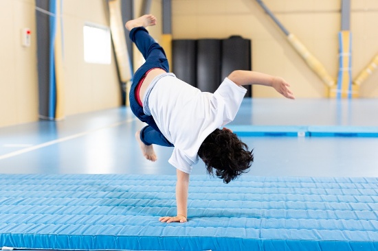 運動プログラムで側転の練習をする子ども。段階を経て、少しずつ「できる」を積み上げていく(写真提供:チェーロスポーツ保育園、以下同)